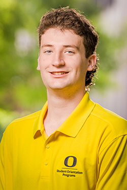 Male with short brown hair wearing a yellow polo shirt