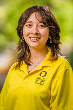 Woman with shoulder-length brown hair in a yellow polo shirt